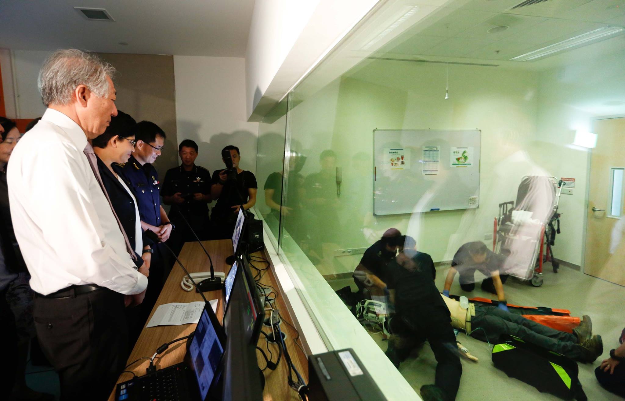 DPM Teo Chee Hean observing SCDF paramedics administering advanced cardiac life support on a computerised mannequin inside the simulation lab, together with Assoc Prof Fatimah Lateef and Commissioner Eric Yap (Source : SCDF Facebook page).